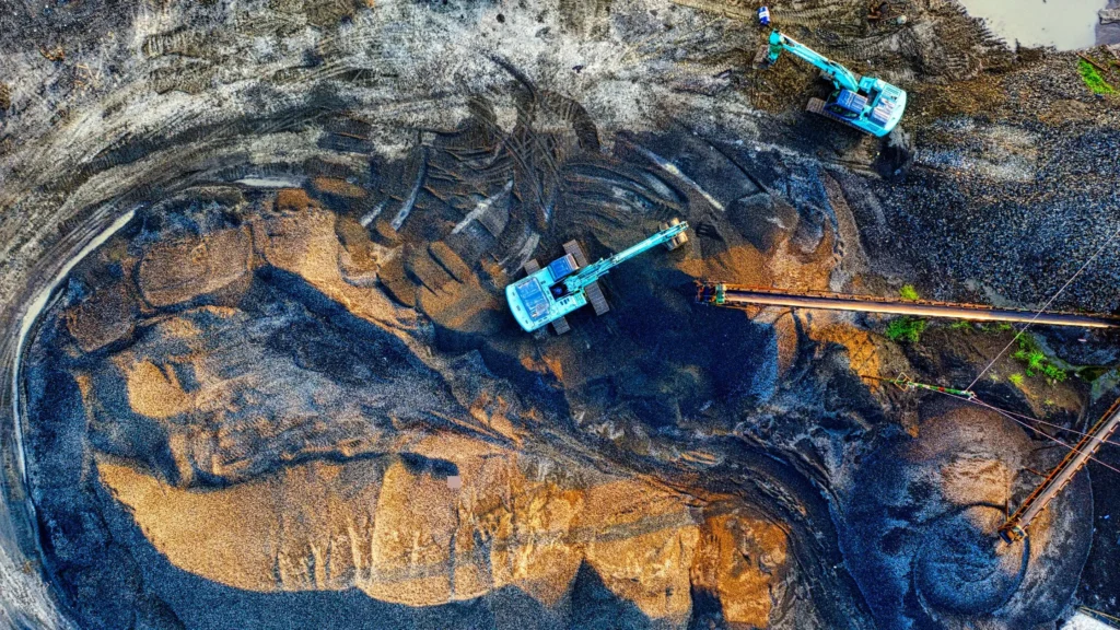 Excavators working in open-pit mine—CNC machining in precision mining equipment and mineral extraction machinery.