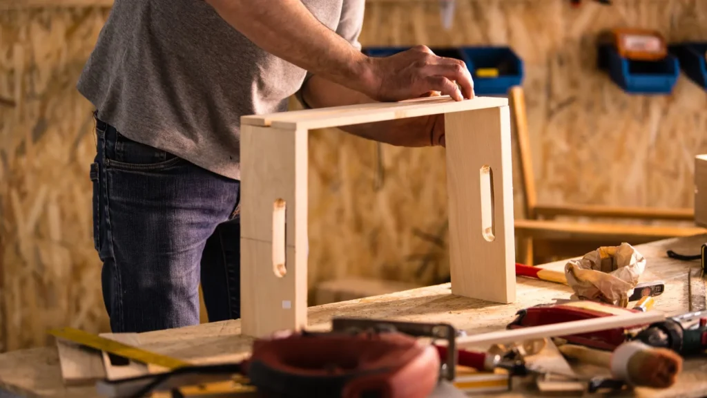 Carpenter assembling wooden furniture parts—CNC machining in precision woodworking and custom furniture manufacturing.