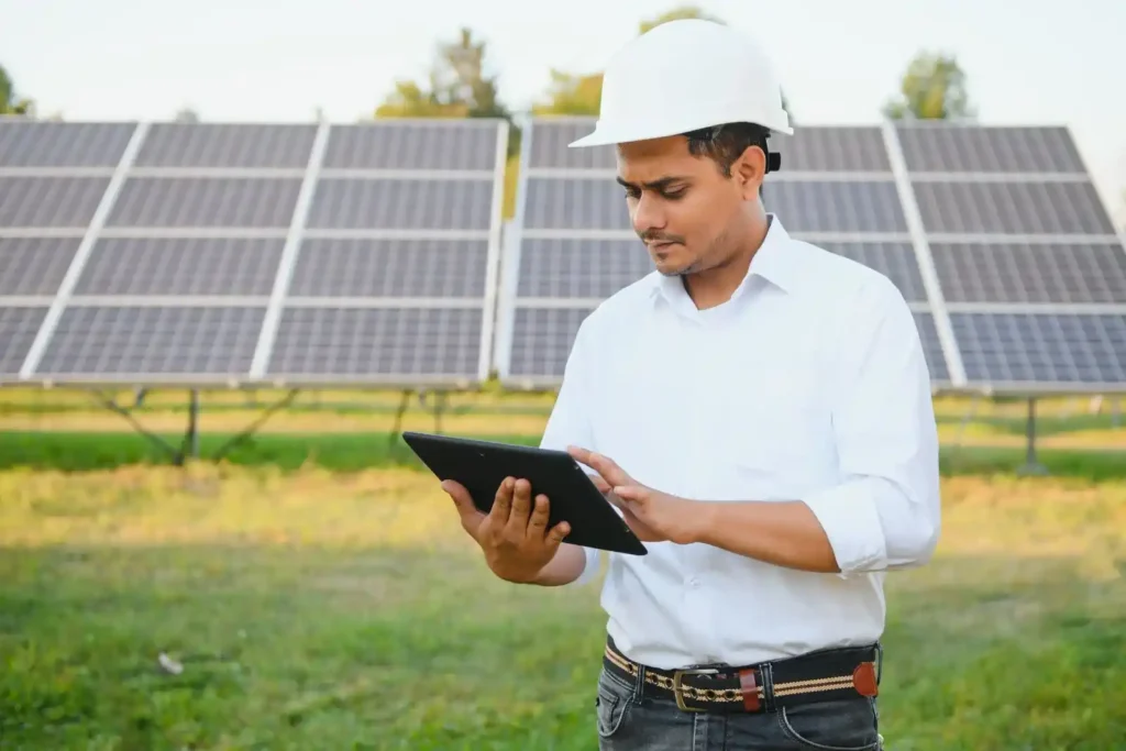 Engineer inspecting solar panels using a tablet at a renewable energy site