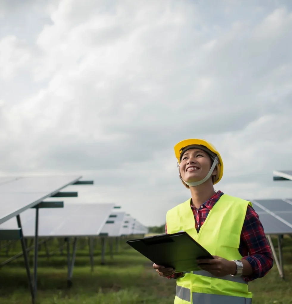 Engineer inspecting solar panels at a renewable energy site using a clipboard